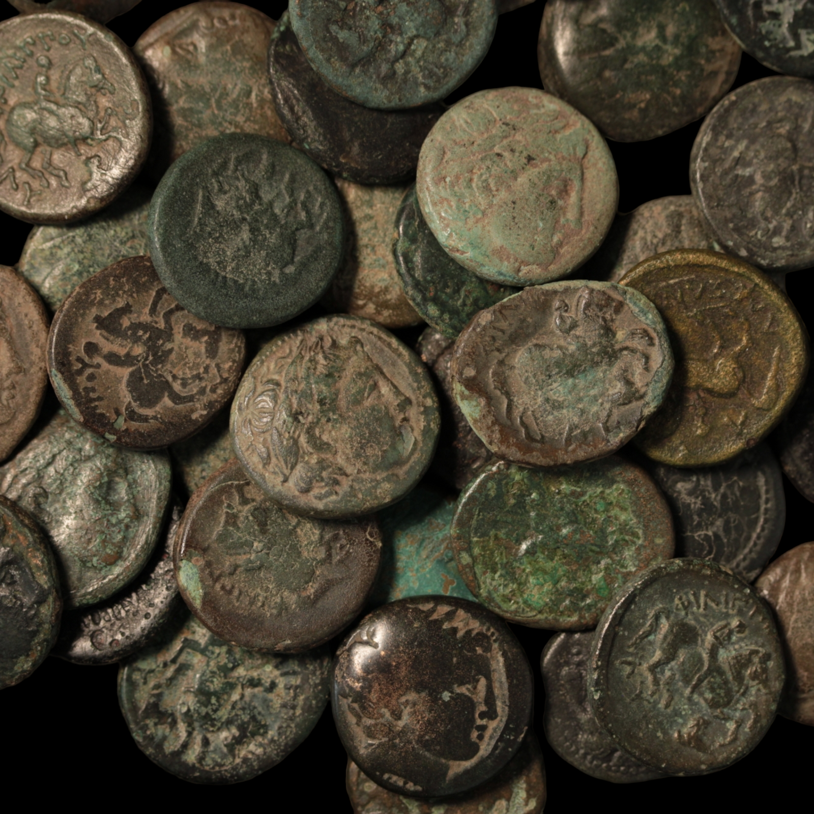 Ancient bronze coins of Macedon, minted under Philip II, spread out over a dark background.