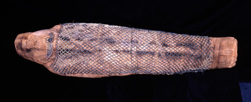 Mummy of the young adult woman Takhebkhenem, with linen wrappings covered by a bead-net of blue glazed faience. (Source: The British Museum)