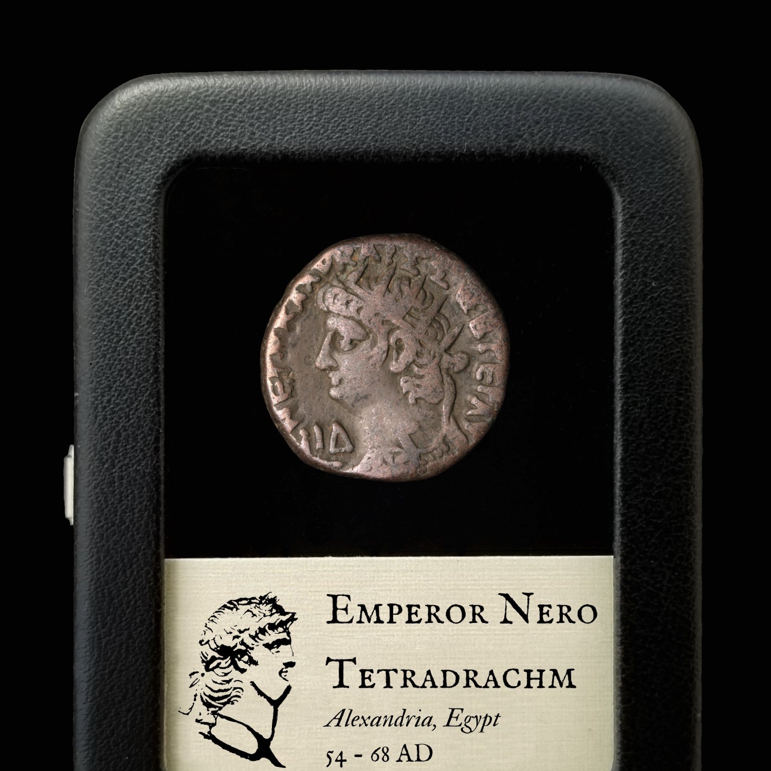 An ancient coin from the Roman Empire, Nero Tetradrachm, displayed in a case with a description label.