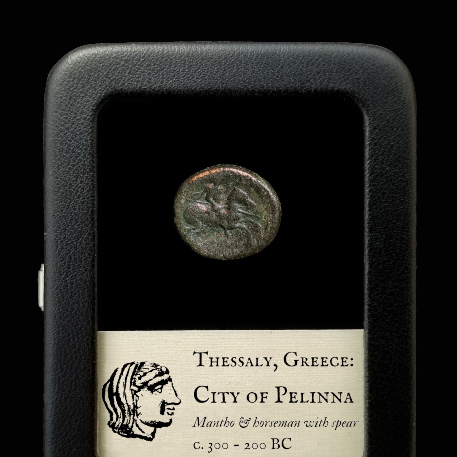 Ancient coin from Thessaly, Greece, displayed in a case with descriptive label.